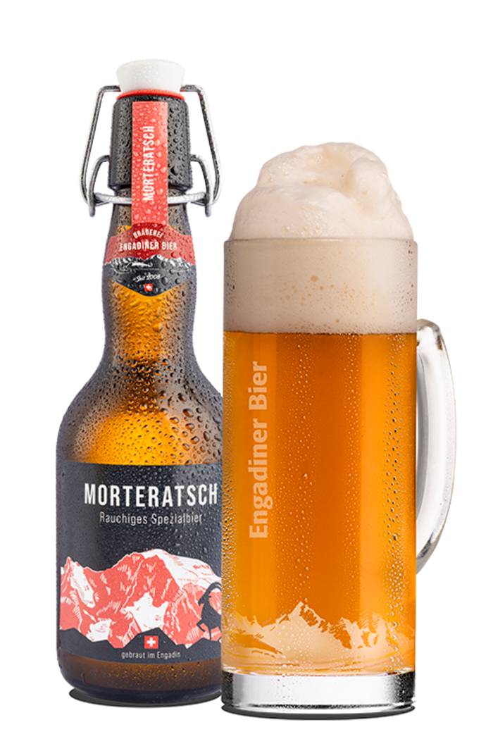 Das Bild zeigt eine Bierflasche und ein mit Bier gefülltes Glas. Die Etikette enthält die Hintergrundfarbe schwarz und bildet den Piz Morteratsch in leichtem rot und weiss gezeichnet ab. Morteratsch ist zugleich der Name des rauchigen Bieres.