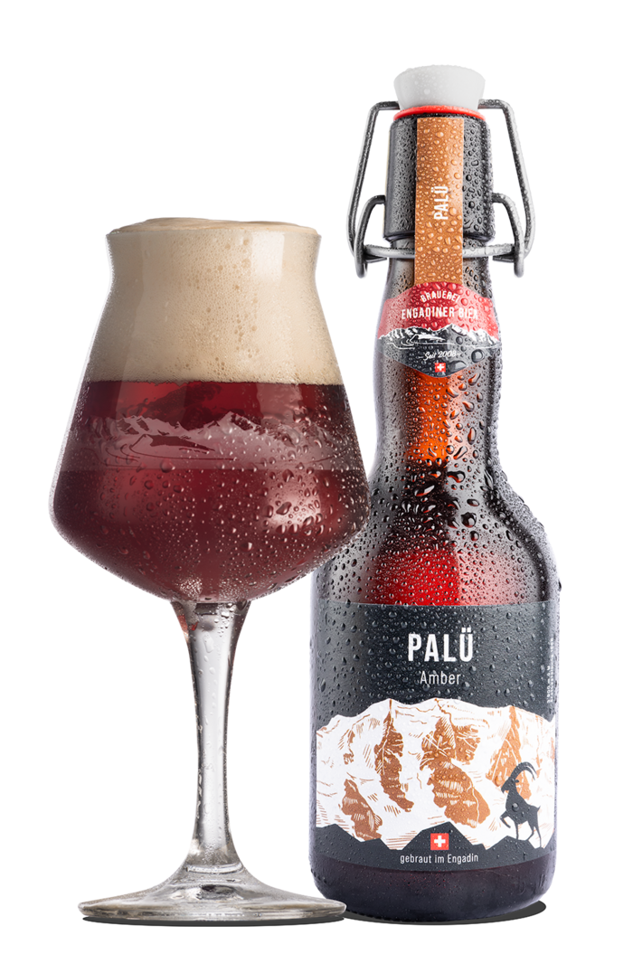 Das Bild zeigt eine Bierflasche und ein mit Bier gefülltes Glas. Die Etikette enthält die Hintergrundfarbe schwarz und bildet den Piz Palü in braun und weiss gezeichnet ab. Palü ist zugleich der Name des Amber Bier.