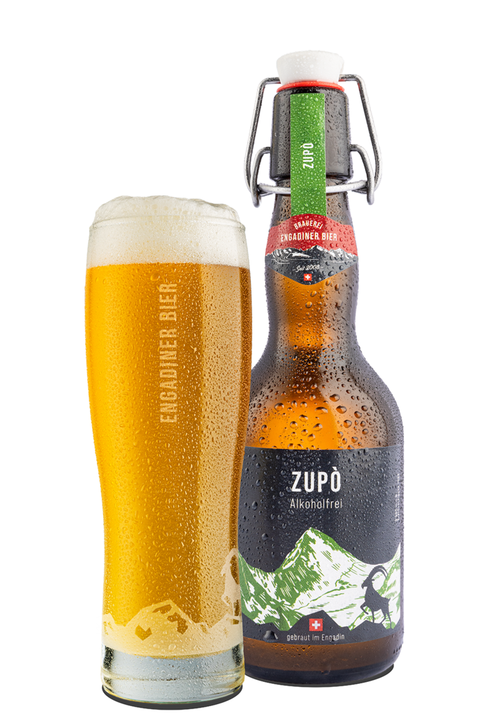 Das Bild zeigt eine Bierflasche und ein mit Bier gefülltes Glas. Die Etikette enthält die Hintergrundfarbe schwarz und bildet den Piz Zupò in grün und weiss gezeichnet ab. Zupò ist zugleich der Name des alkoholfreien Bier.